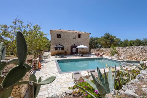 an external view of a villa with a swimming pool at Aresti Mountain Resort in Agios Leon