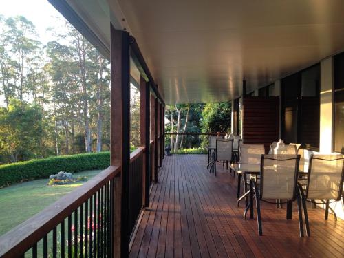 a deck with tables and chairs on a house at Mapleton Falls Accommodation in Mapleton