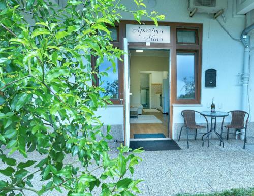 a building with a table and chairs outside of it at Apartma Alina in Lucija