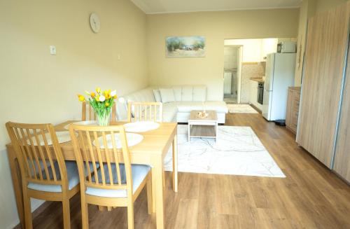 a kitchen and living room with a table and chairs at Apartma Alina in Lucija