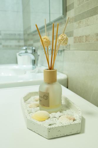 a vase with sticks in it sitting on a bathroom counter at Apartma Alina in Lucija