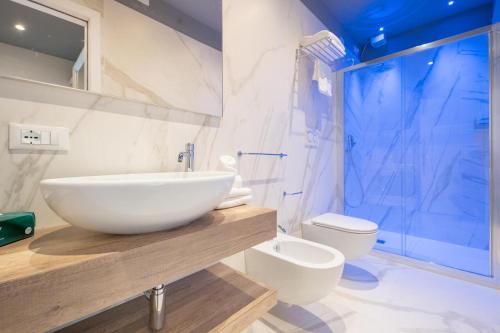 a bathroom with a white sink and a toilet at Park Hotel Pineta Boutique Hotel in Caorle