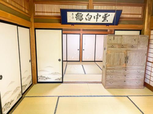 ein Zimmer mit Glastüren und einem Schild an der Wand in der Unterkunft 自然豊かな古民家豪邸 最大12名まで可 大人数に最適可で アクセス良好な 菱閣 in Fujikawaguchiko