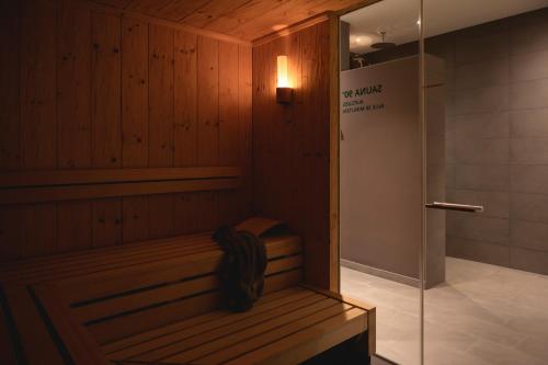 a sauna with a bench and a shower in a room at Sport- & Seminarhotel Glockenspitze in Altenkirchen