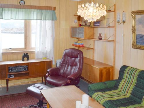a living room with a chair and a table at 6 person holiday home in Sandhornøy in Røssnes