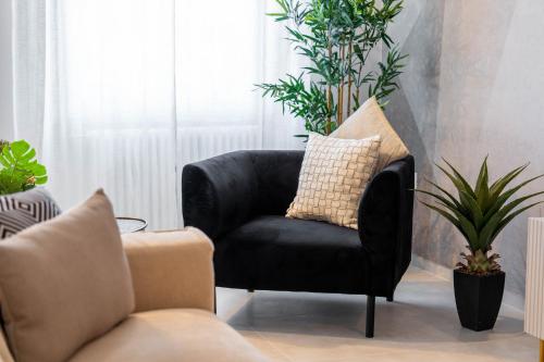 a black chair in a living room with plants at Osmann Space in La Spezia