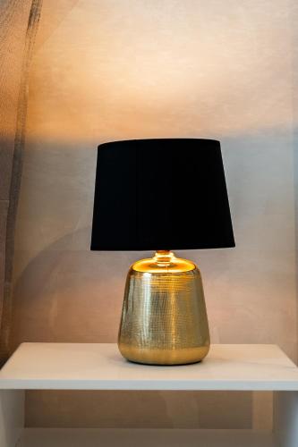 a gold lamp sitting on a white shelf at Osmann Space in La Spezia