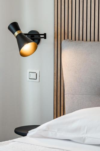a lamp on a wall next to a bed at Osmann Space in La Spezia