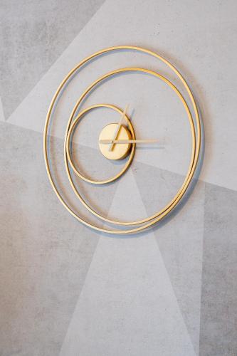 a clock with gold rings on a wall at Osmann Space in La Spezia