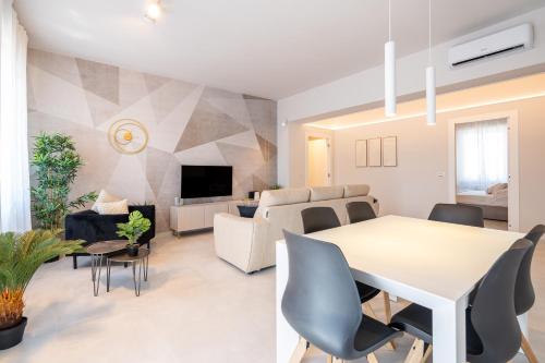 a dining room and living room with a white table and chairs at Osmann Space in La Spezia