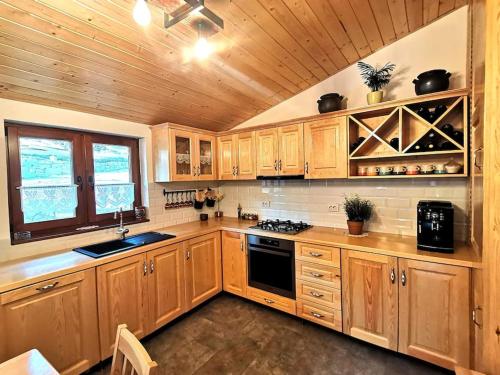 una cucina con mobili in legno e un forno a piano cottura di Casa din Cucă a Cornereva