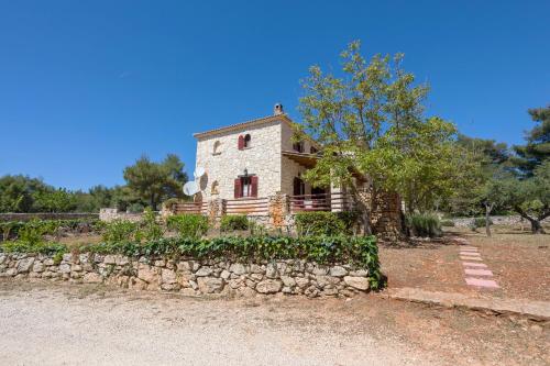 an old stone house with a stone wall at Aresti Mountain Resort in Agios Leon