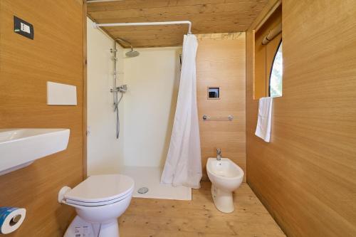 a bathroom with a toilet and a sink and a shower at Suite Glamping vicino al mare in Piombino