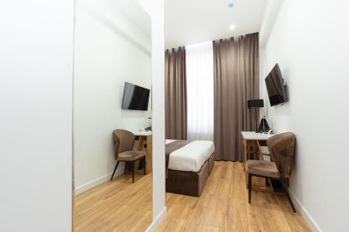 a hotel room with a bed and a desk at Harmony Luxury Hotel Tashkent in Tashkent