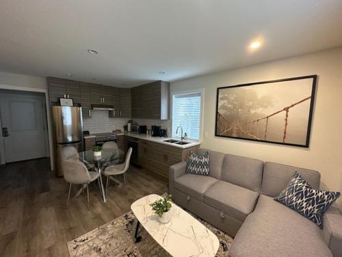 a living room with a couch and a kitchen at Bright and cozy modern home in Vancouver - central to YVR-Downtown - Free Private Parking in Vancouver