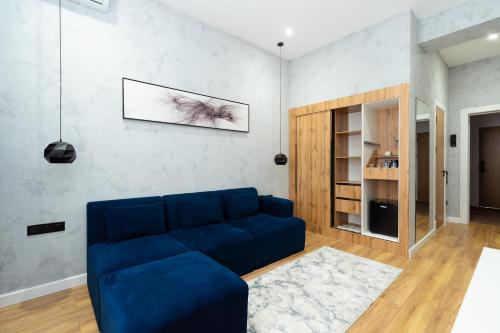 a blue couch in a living room with a wall at Harmony Luxury Hotel Tashkent in Tashkent