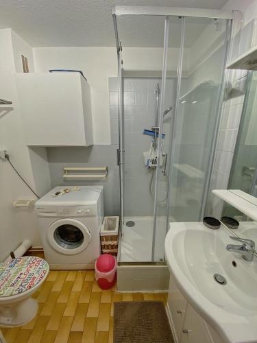 a bathroom with a shower and a washing machine at Carnon-plages - Agréable Studio cabine in Mauguio