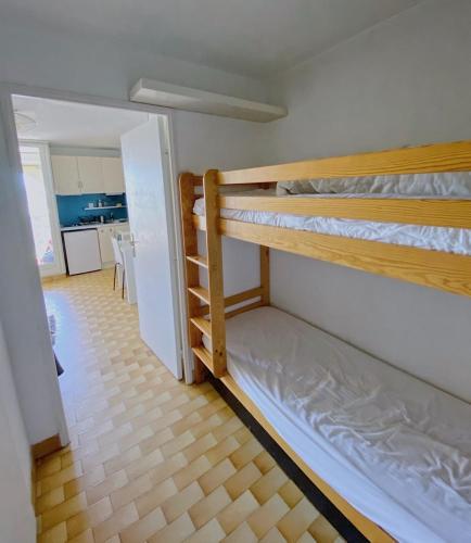 two bunk beds in a room with a kitchen at Carnon-plages - Agréable Studio cabine in Mauguio