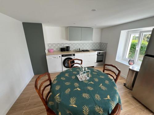 une cuisine avec une table et des chaises ainsi qu'une cuisine avec une table et une table dans l'établissement Appartement Golfe du Morbihan- 2 pers, à Arzon