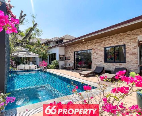 a swimming pool in front of a house at Phuk Phirom Twin Villas in Chiang Mai