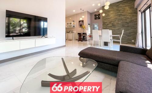 a living room with a couch and a tv at Phuk Phirom Twin Villas in Chiang Mai
