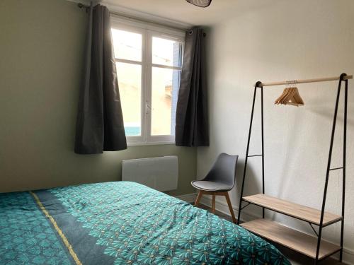 une chambre avec un lit, une chaise et une fenêtre dans l'établissement CARC'APPART Appartements à Carcassonne, à Carcassonne