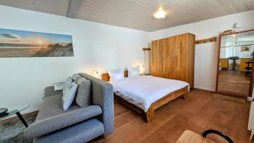 a bedroom with a bed and a couch at De Lütte Seileree in Ahlbeck
