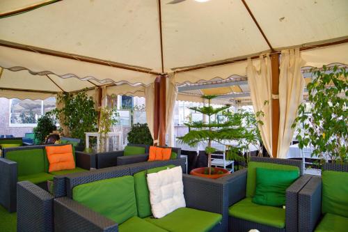 a tent with green and orange chairs and plants at Hotel Polamar in Santa Pola