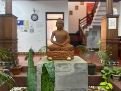 a statue of a woman sitting in a room at Nivaasana Bed & Breakfast in Kalpetta