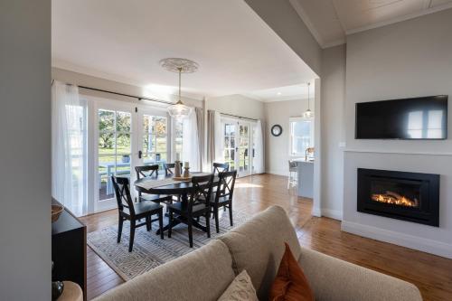 a living room with a table and chairs and a fireplace at Pokolbin Farm Stay in Pokolbin