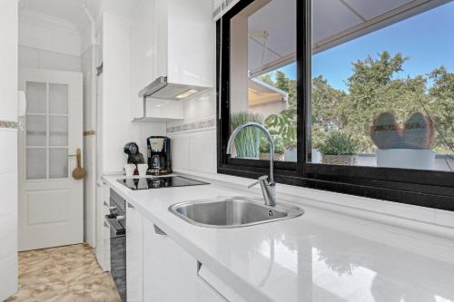 Una cocina blanca con fregadero y ventana. en Roof With Terrace, en San Andrés