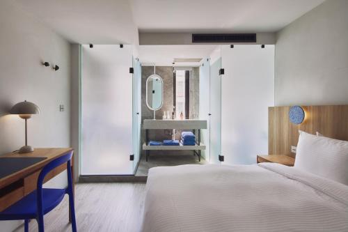 a bedroom with a bed and a desk and a mirror at The Blue by Just Inn in Taipei
