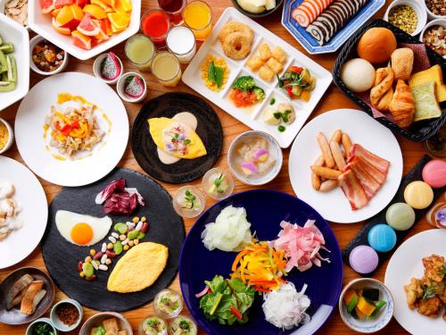 a table full of plates of food with different foods at Kanazawa Sainoniwa Hotel in Kanazawa