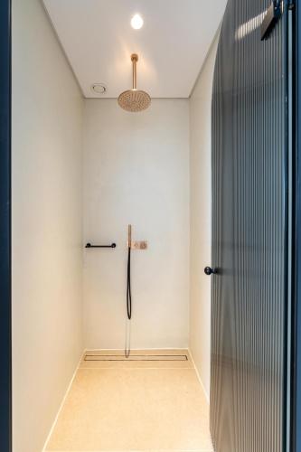 a bathroom with a shower and a glass door at Muse οf Mykonos Luxury Suites in Mýkonos City