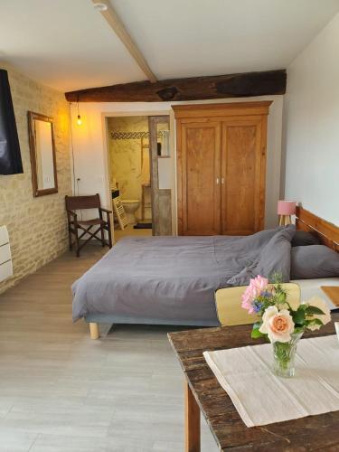 a bedroom with a bed and a table with flowers at Damvix Chambre d hôtes La Barbée in Damvix