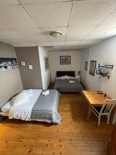 a bedroom with two beds and a wooden table at bdm in Montastruc-la-Conseillère