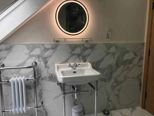 a bathroom with a sink and a mirror at Little Grey Barn in Pagham