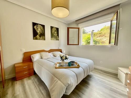 a bedroom with a large bed and a window at Casa Lala Cudillero 1 in Cudillero