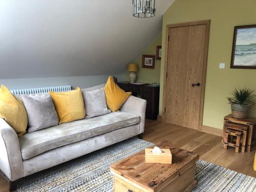 a living room with a couch and a table at Little Grey Barn in Pagham