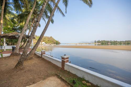 a view of a beach with palm trees and water at Rio De talpona in Magdāl
