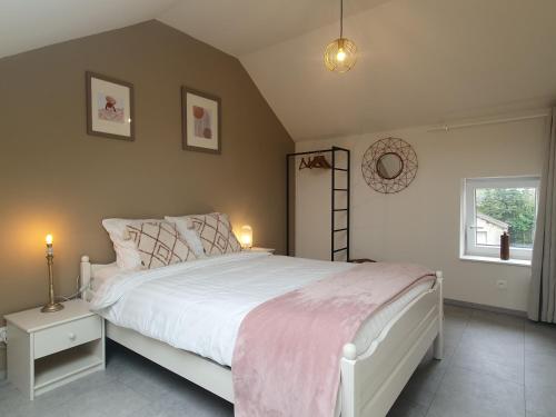 Un dormitorio con una cama blanca y una ventana. en Le Nid de la Trappiste - MAISON avec JARDIN et BARBECUE, en Rochefort