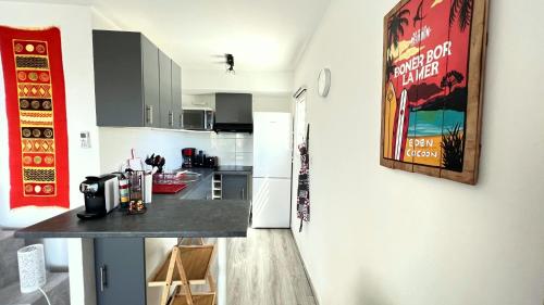 a kitchen with a counter top in a room at L'Eden Cocoon 3 étoiles proche plage Saint Gilles les Bains in Saint-Gilles les Bains
