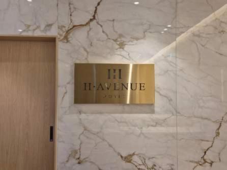 a sign on a marble wall in a bathroom at H avenue Hotel Jeonju Deokjin in Jeonju
