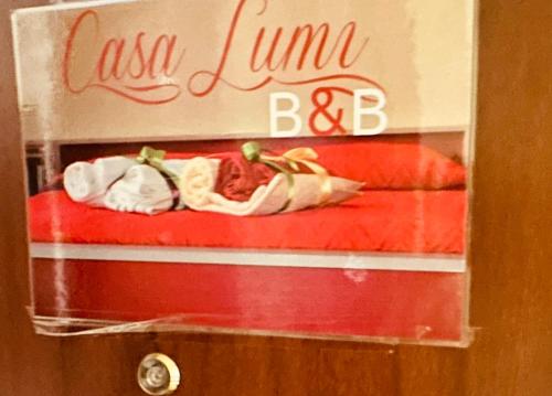 a box with two hot dogs on a bed at Casa Lumi in Bresso