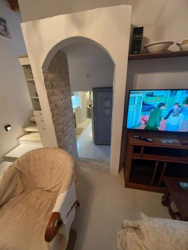 a living room with a tv and a bed in a room at Case De Drymona 1 in Kýthira