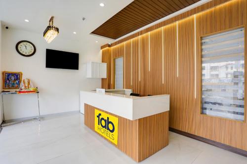 an office lobby with a job counter and a clock at FabHotel Prime Panchwati Regency in Bhopal