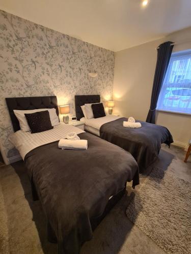 a bedroom with two beds with towels on them at Meadowside Holiday Apartments in Torquay
