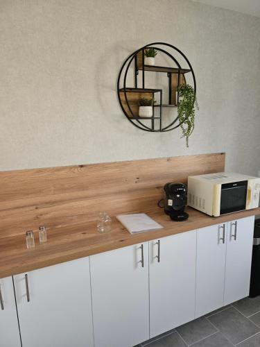 - un comptoir avec un four micro-ondes et un miroir mural dans l'établissement Bord de Loire, à Avaray