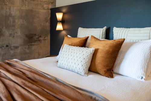 a bed with brown and white pillows on it at Pokolbin Farm Stay in Pokolbin