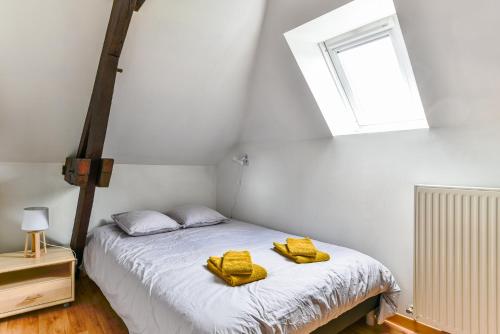 - une chambre avec un lit et des serviettes jaunes dans l'établissement Appartement spacieux et lumineux - Centre - Bord Loire - Climatisation - Wifi - Tout Confort, à Saumur